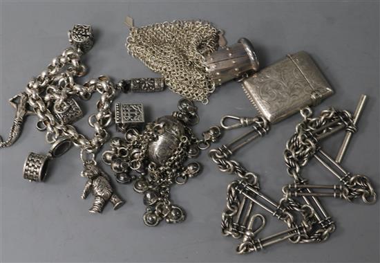 A silver charm bracelet, an Edwardian vesta on silver albert, a white metal purse and a continental white metal pill box with tassels